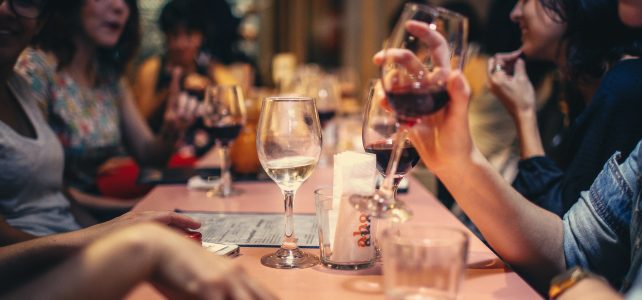 Comment bien déguster son vin ? Groupe d'amis qui boivent du vin pendant un repas au restaurant